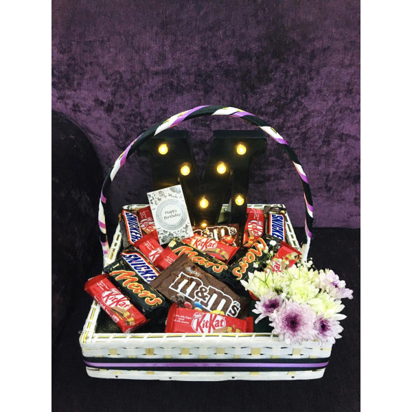 Chocolate basket with a led letter and fresh flowers with one heart balloon and net wrapping 